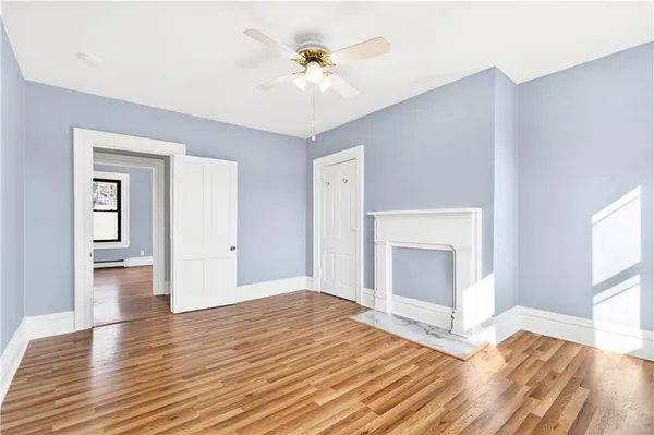 a view of empty room with wooden floor and fireplace