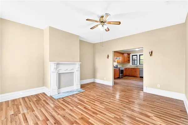 a view of a livingroom with wooden floor and a ceiling fan