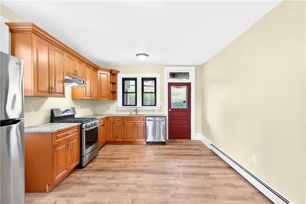 a kitchen with stainless steel appliances granite countertop a stove a sink and a refrigerator