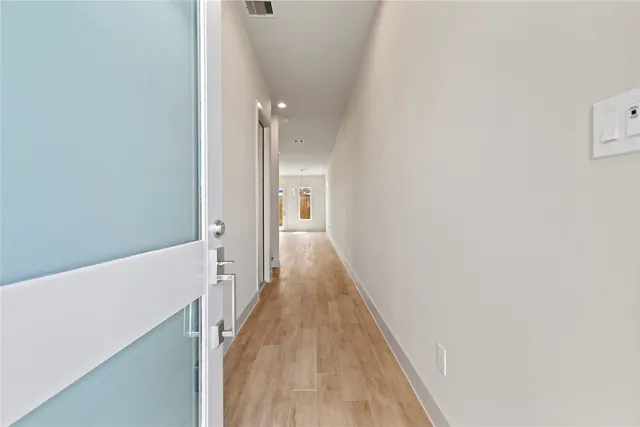 a view of a hallway with wooden floor