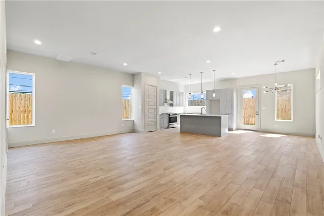 a view of a big room with wooden floor and windows