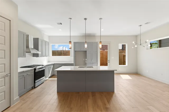a view of kitchen with granite countertop stainless steel appliances sink and wooden floor