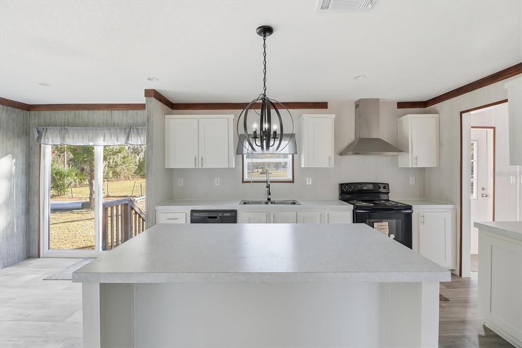 6919 South Sorrell Avenue Homosassa, FL 34446 - Photo 11 of 30 a kitchen with kitchen island a counter top space a sink a stove and a window