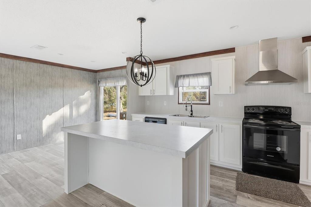 6919 South Sorrell Avenue Homosassa, FL 34446 - Photo 6 of 30 a kitchen with stainless steel appliances granite countertop a sink a stove and a wooden floors