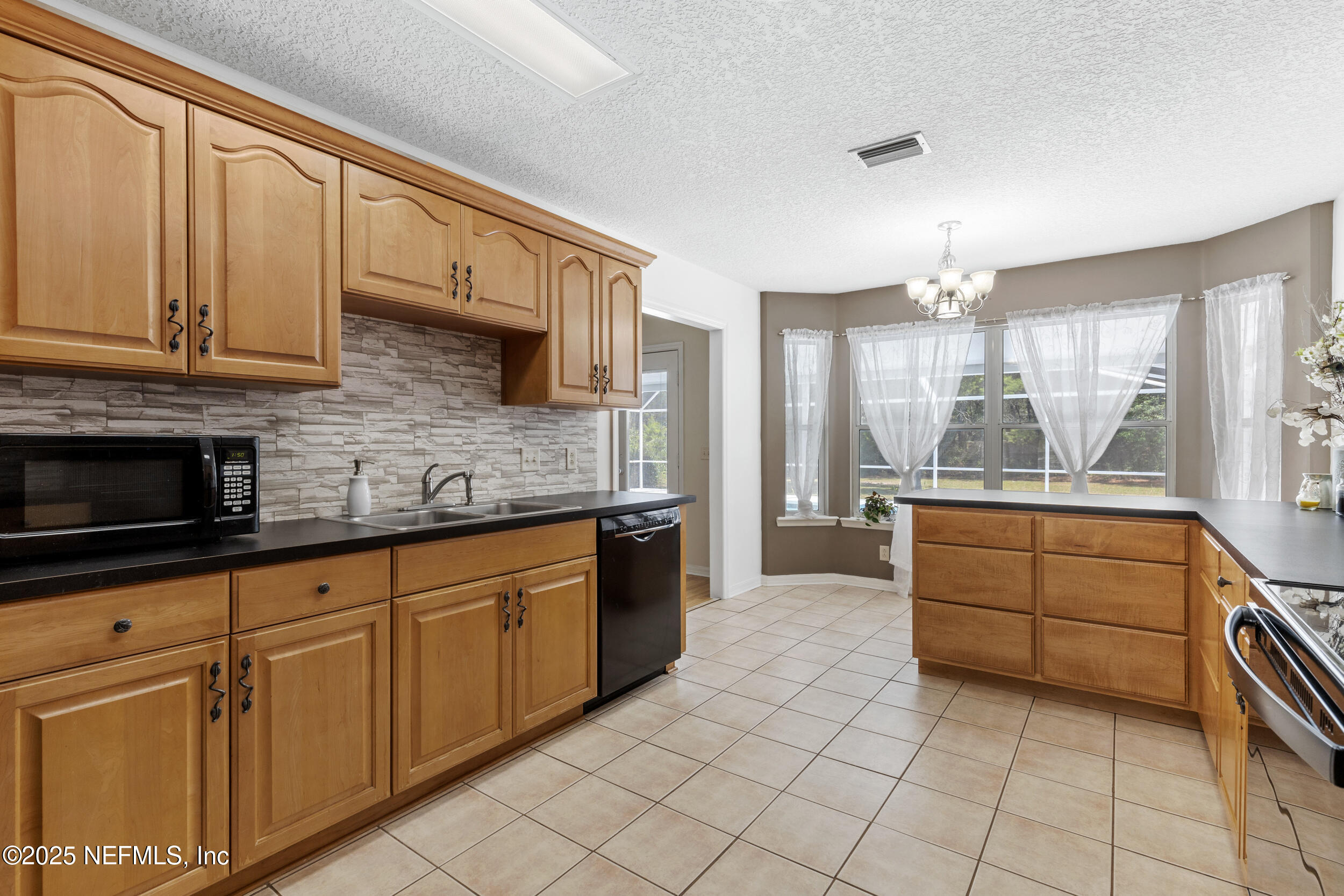 7557 Alameda Way Keystone Heights, FL 32656 - Photo 11 of 40 a kitchen with stainless steel appliances granite countertop a sink and cabinets