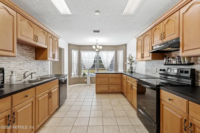 a large kitchen with stainless steel appliances granite countertop a stove a sink and a granite counter tops