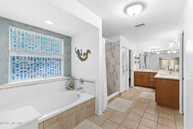 a spacious bathroom with a tub a sink and a large mirror
