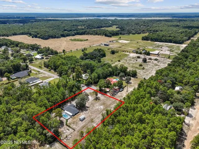 an aerial view of residential houses with outdoor space and river