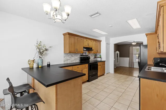 a kitchen with stainless steel appliances granite countertop a sink dishwasher stove refrigerator and cabinets