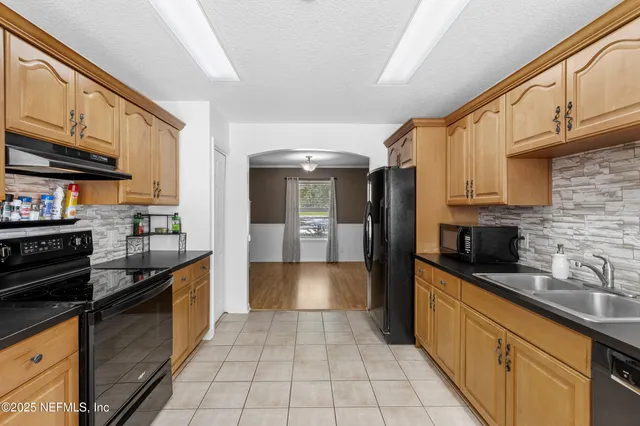 a large kitchen with stainless steel appliances granite countertop a stove and a sink