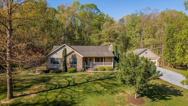 a view of house that has a lot of plants and trees around