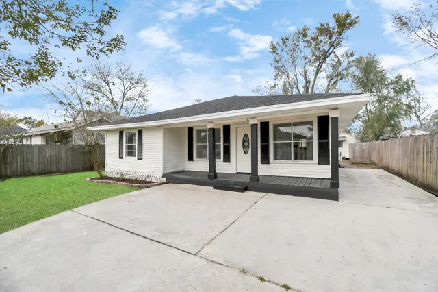 front view of a house with a yard and potted plants