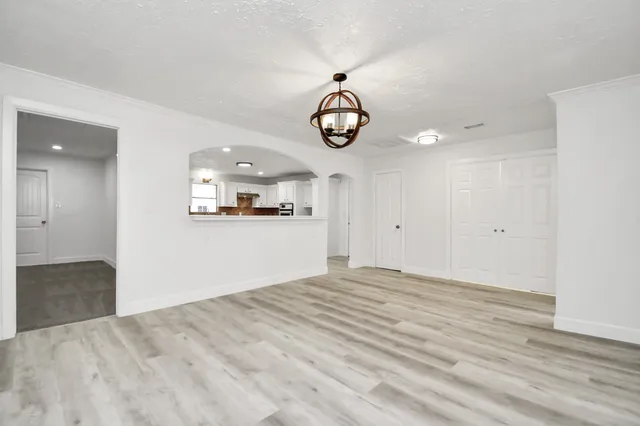a view of empty room with wooden floor and ceiling fan