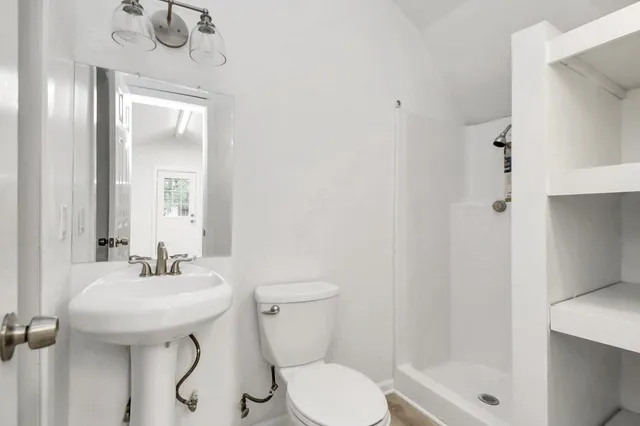 a bathroom with a sink a toilet and shower