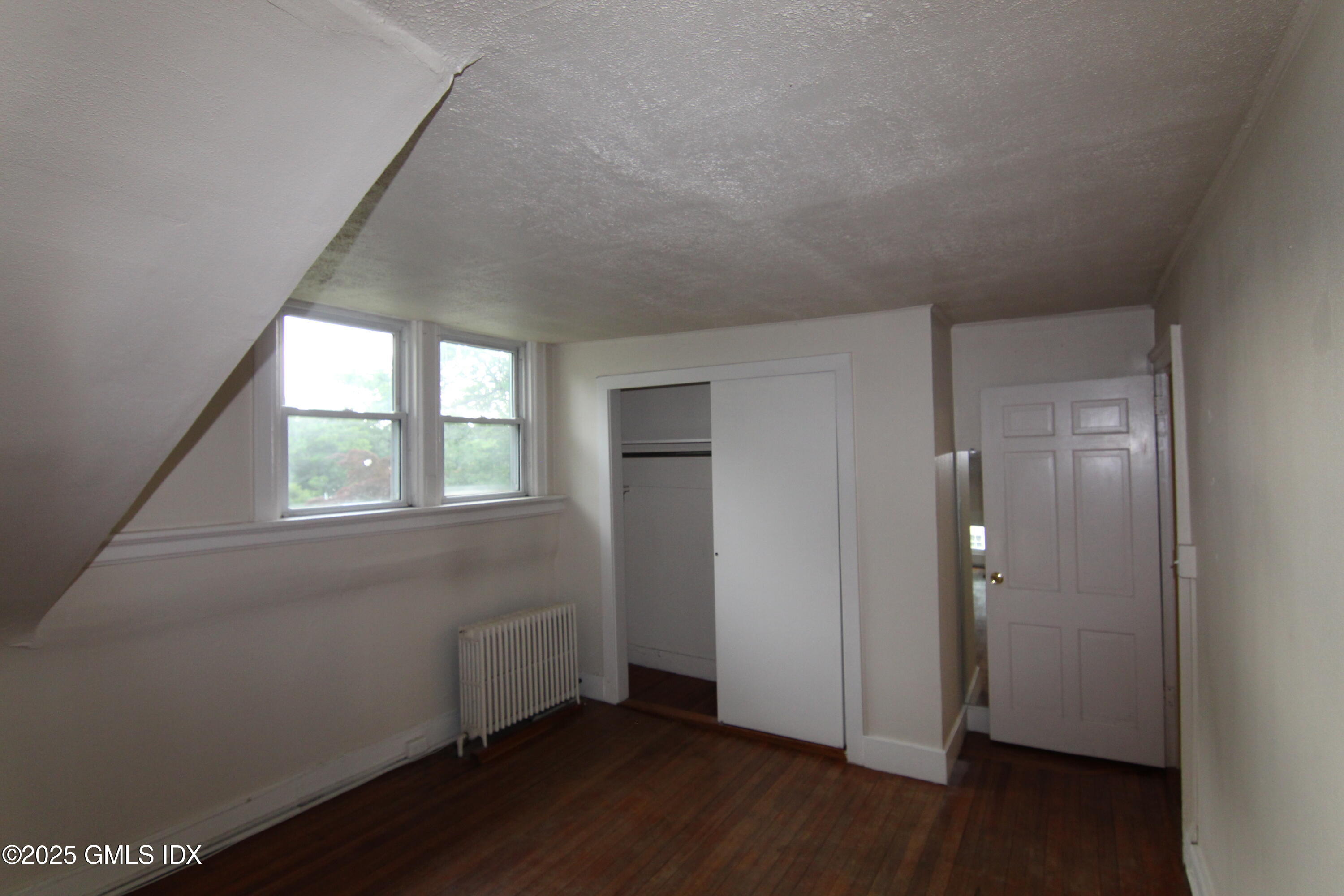 90 Riverside Avenue, Unit 5 Riverside, CT 06878 - Photo 13 of 13 an empty room with wooden floor and windows