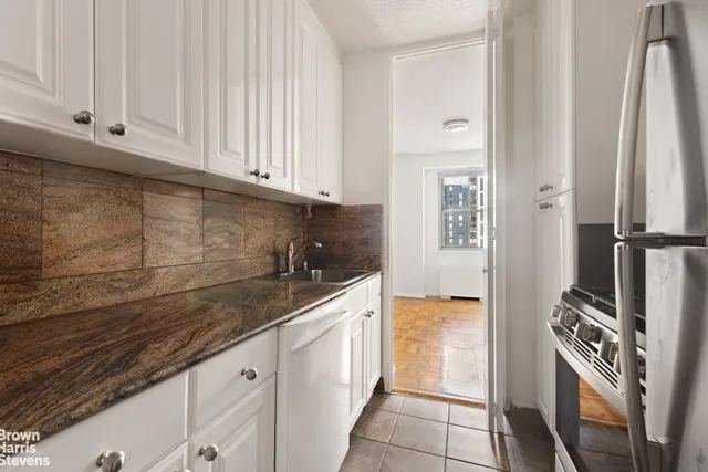 a living room with furniture a window and a potted plant