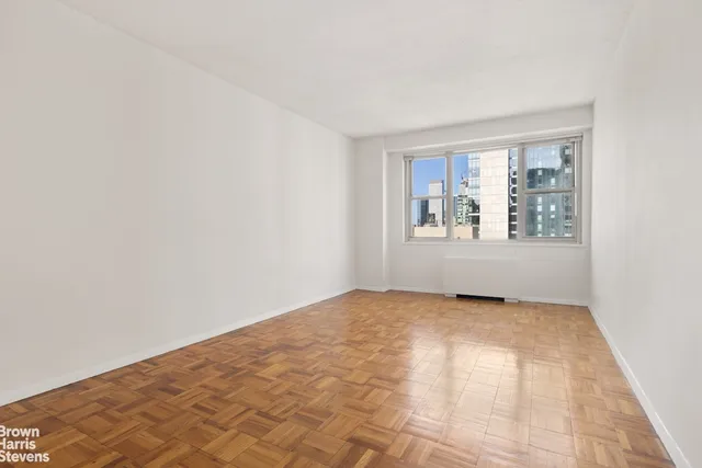 a bedroom with a large bed flat screen tv and a large window