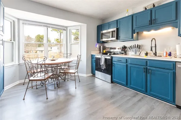 a kitchen with furniture a sink a window and stainless steel appliances