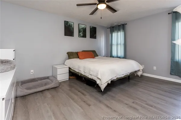 a bedroom with a large bed and a flat tv screen on dresser