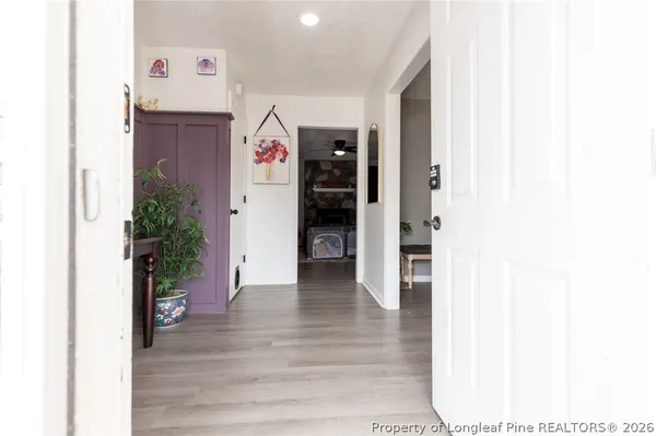 a view of a hallway with wooden floor and closet