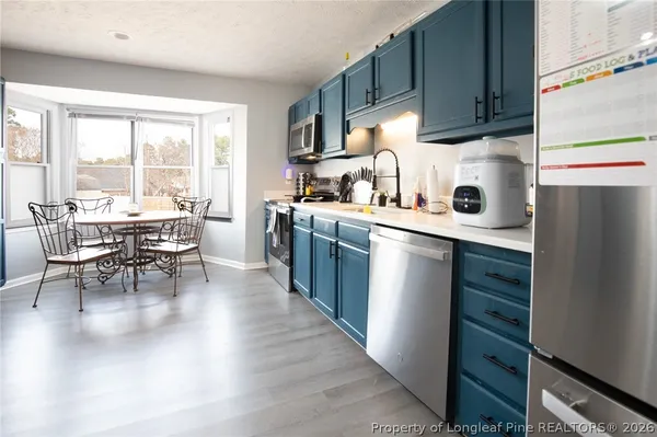 a kitchen with stainless steel appliances granite countertop a refrigerator stove a sink and dishwasher with wooden floor