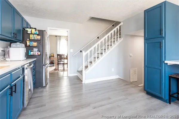a kitchen with stainless steel appliances granite countertop wooden floors a stove top oven a sink with granite countertops and cabinets