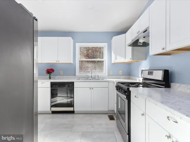 a kitchen with granite countertop a sink stainless steel appliances and cabinets