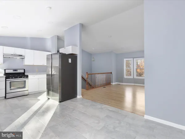 a kitchen with a refrigerator and a stove top oven