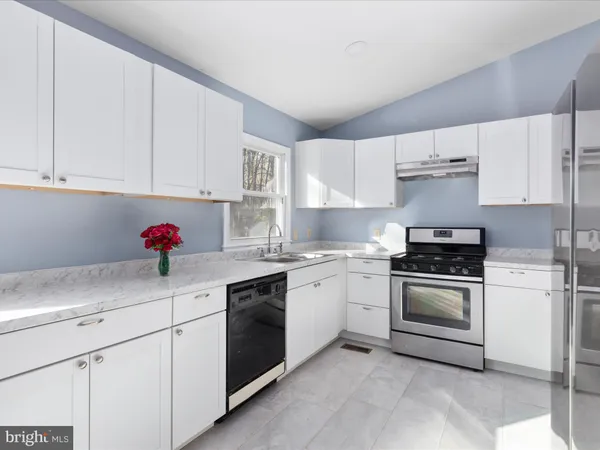 a kitchen with white cabinets and white appliances
