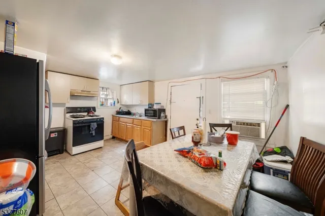 a kitchen with stainless steel appliances kitchen island granite countertop a table chairs and a refrigerator