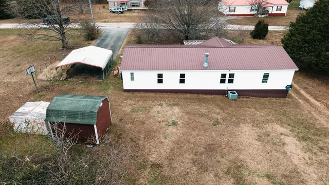 a view of a white house with a large window and wooden fence