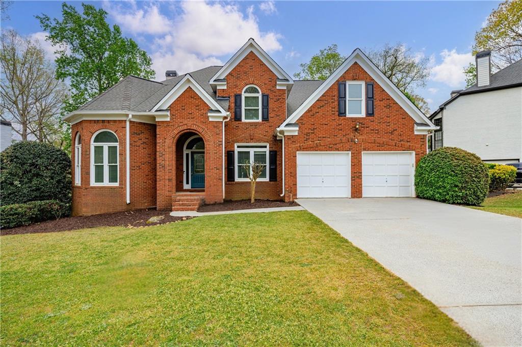 6010 Masters Club Drive Suwanee, GA 30024 - Photo 1 of 82 a front view of a house with a yard and garage