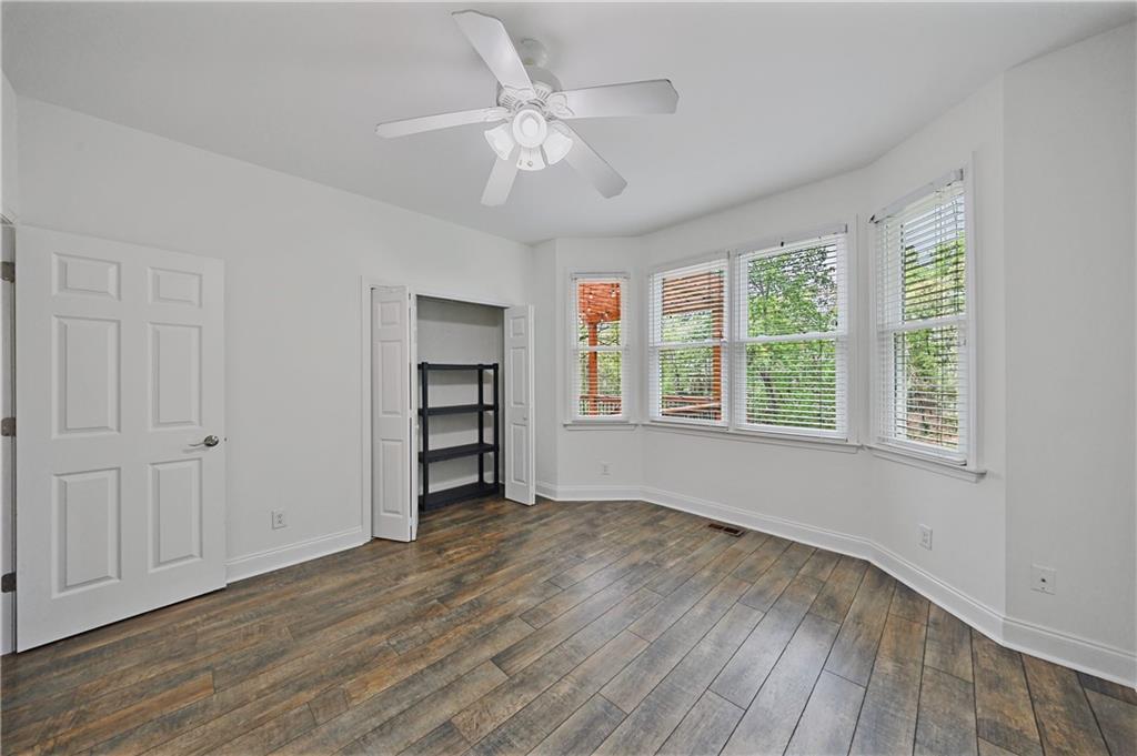 6010 Masters Club Drive Suwanee, GA 30024 - Photo 29 of 82 an empty room with wooden floor chandelier fan and windows