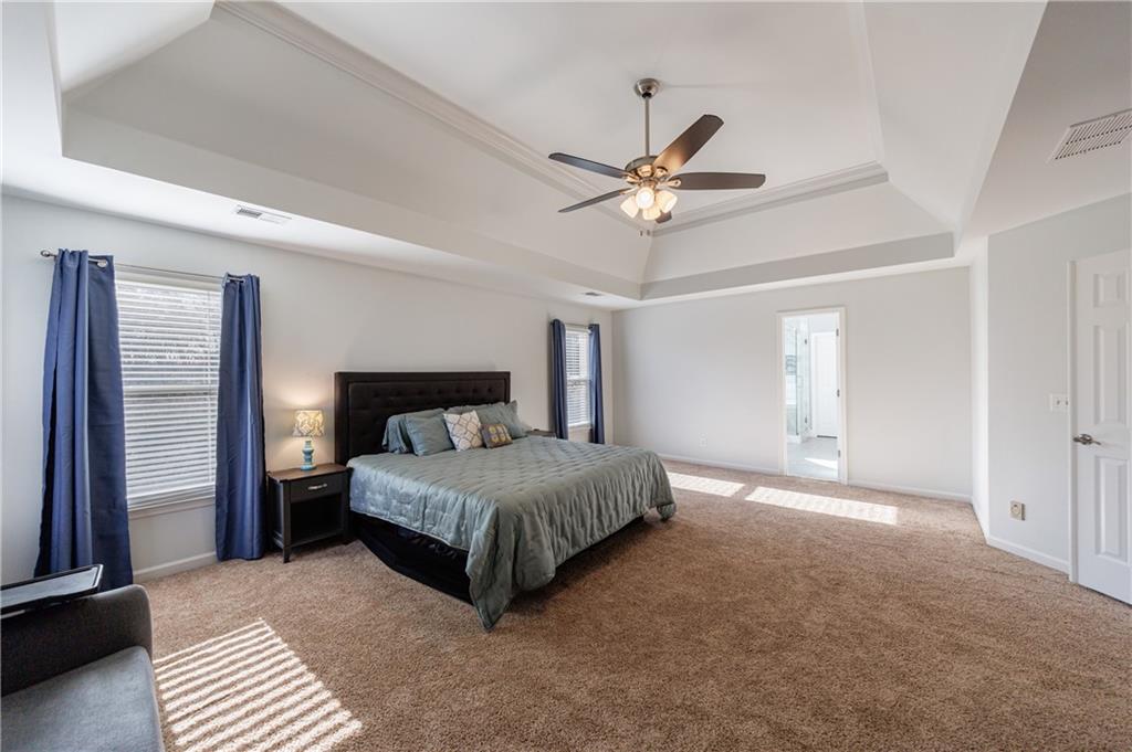 6010 Masters Club Drive Suwanee, GA 30024 - Photo 35 of 82 a bedroom with a large bed and a chandelier