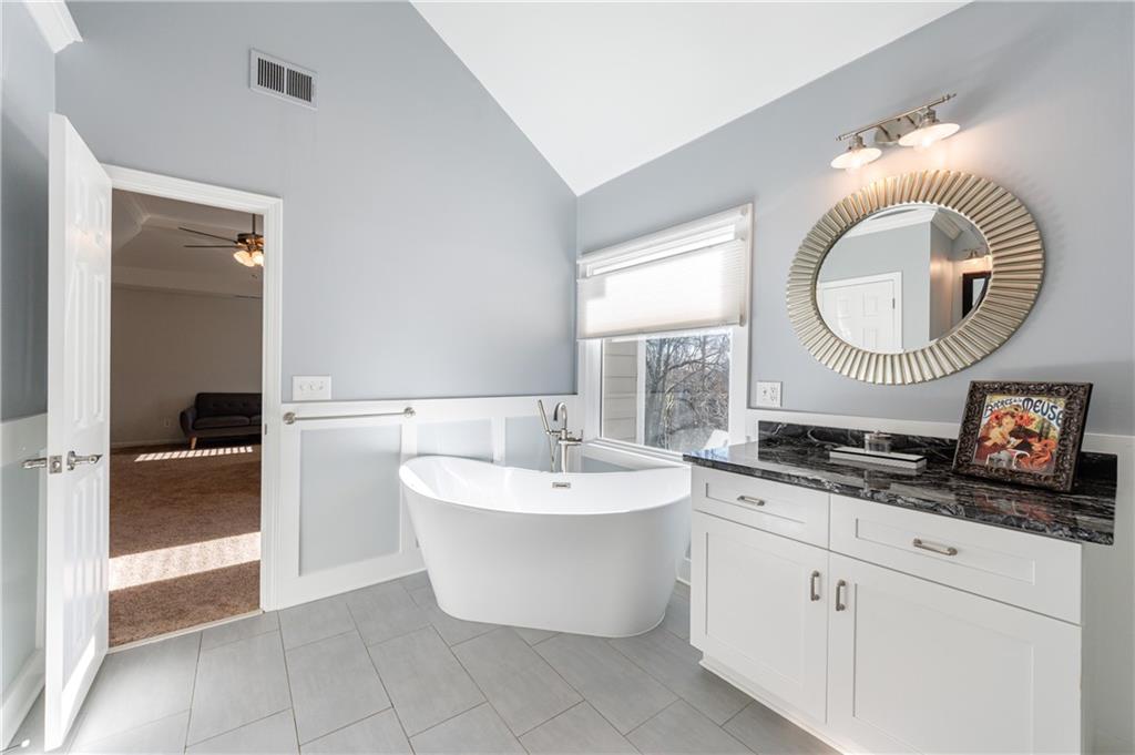 6010 Masters Club Drive Suwanee, GA 30024 - Photo 36 of 82 a spacious bathroom with a double vanity sink a mirror and a bathtub