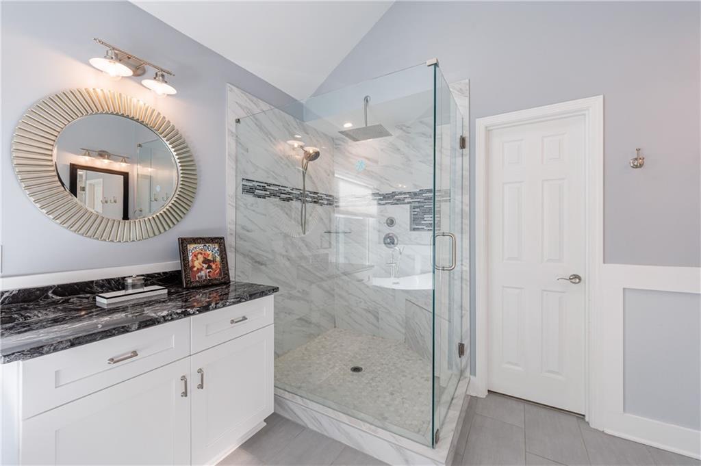 6010 Masters Club Drive Suwanee, GA 30024 - Photo 38 of 82 a bathroom with a sink a mirror a vanity and a shower