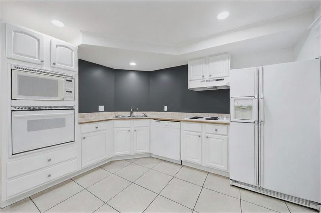 6010 Masters Club Drive Suwanee, GA 30024 - Photo 55 of 82 a kitchen with white cabinets and white appliances