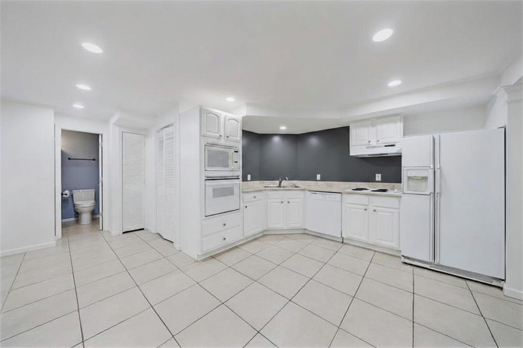 6010 Masters Club Drive Suwanee, GA 30024 - Photo 56 of 82 a kitchen with white cabinets and white appliances