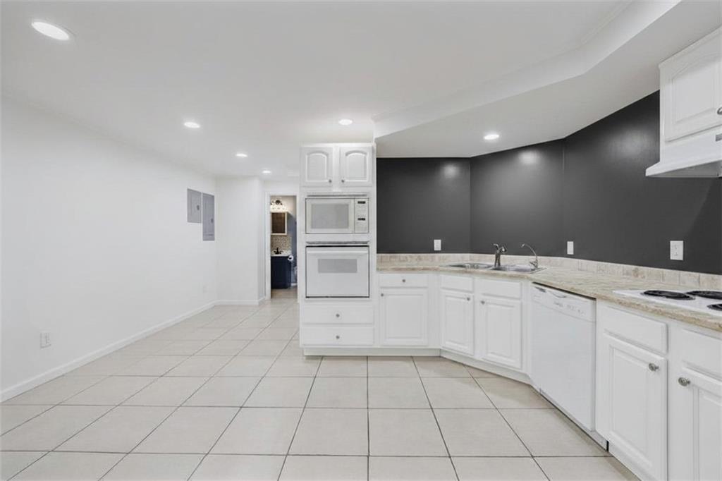 6010 Masters Club Drive Suwanee, GA 30024 - Photo 58 of 82 a large white kitchen with a sink and dishwasher a refrigerator with white cabinets