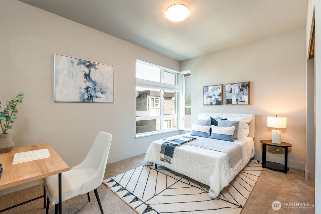 205 4th Court South, Unit 13 Kirkland, WA 98033 - Photo 16 of 33 a bedroom with a bed a table and chair