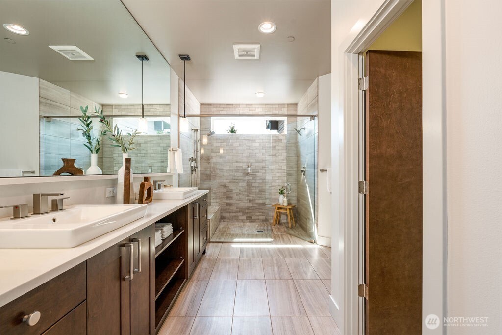 205 4th Court South, Unit 13 Kirkland, WA 98033 - Photo 23 of 33 a bathroom with a granite countertop sink a mirror a bathtub and shower