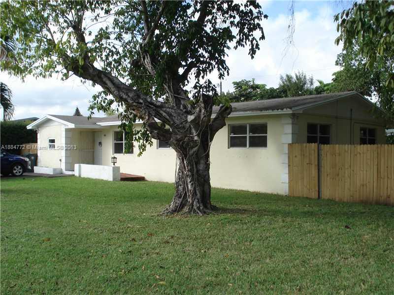a view of a house with a large tree and a yard