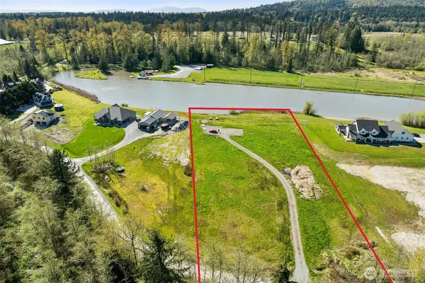 an aerial view of a swimming pool with a yard and lake view