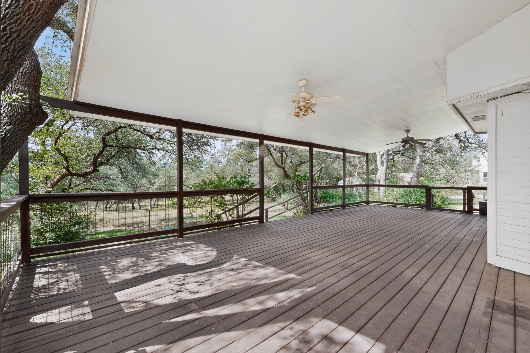 1003 Pier Branch Road Dripping Springs, TX 78620 - Photo 3 of 40 A spacious covered deck offers serene views of the verdant surroundings, perfect for outdoor relaxation.