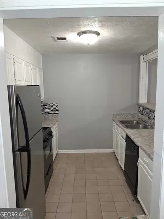 a kitchen with stainless steel appliances granite countertop a refrigerator a stove and a sink