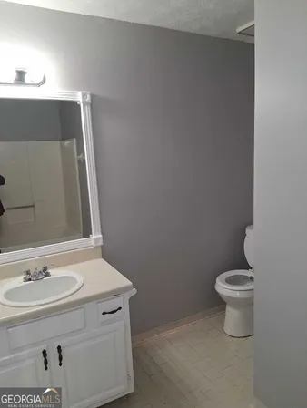 a bathroom with a sink a toilet and mirror