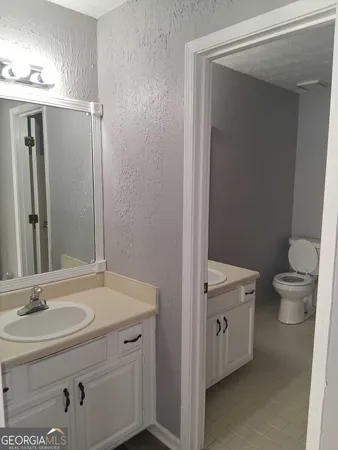 a bathroom with a sink a toilet and a mirror