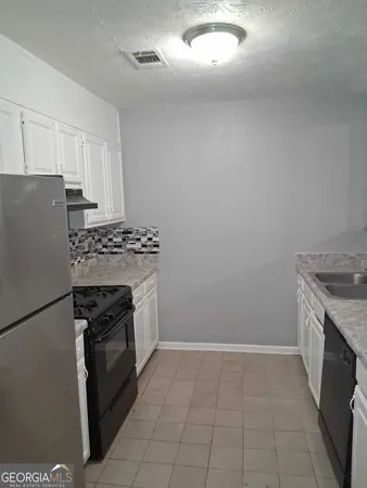a kitchen with a stove top oven and cabinets