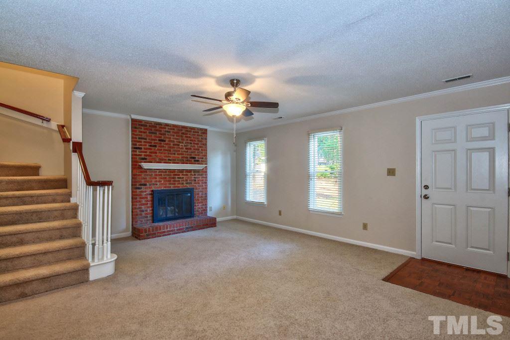 5512 Hamstead Crossing Raleigh, NC 27612 - Photo 3 of 16 a view of a livingroom with a fireplace a ceiling fan and windows