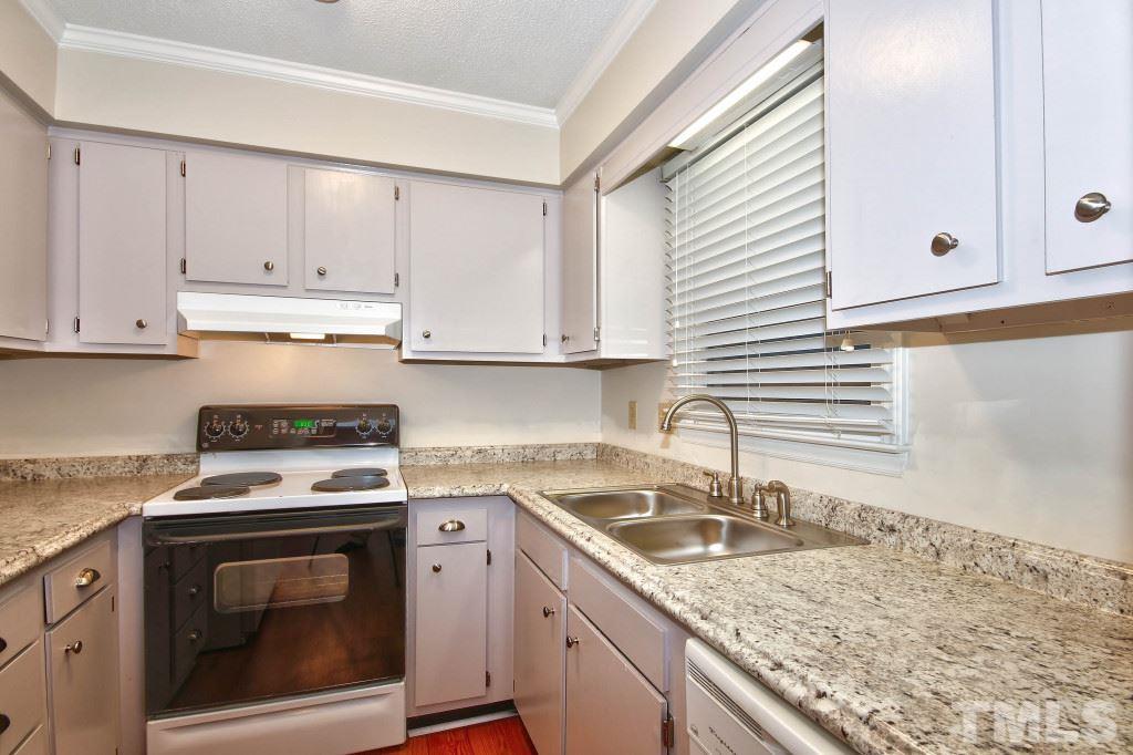 5512 Hamstead Crossing Raleigh, NC 27612 - Photo 5 of 16 a kitchen with granite countertop a sink stove top oven and cabinets